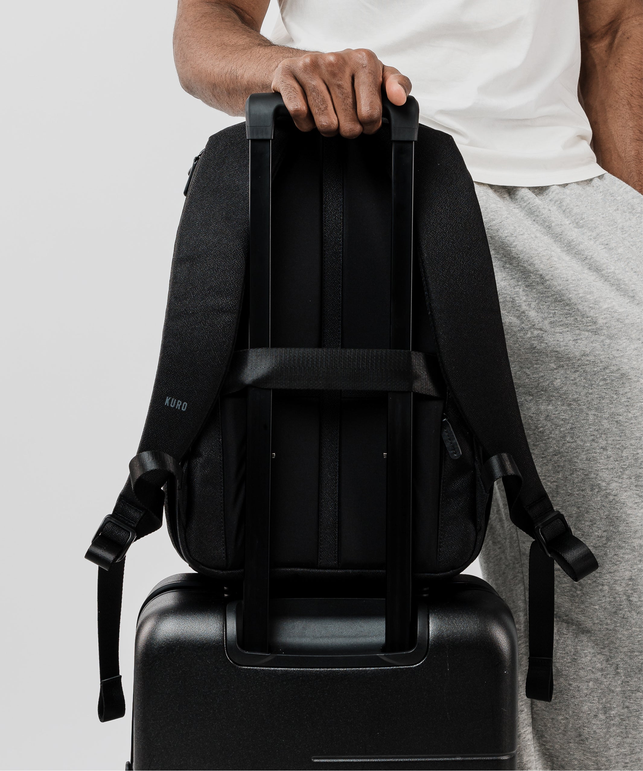 Kuro Essentials Everyday Workpack secured on a suitcase handle with luggage pass-through – best travel backpack for men in 2025