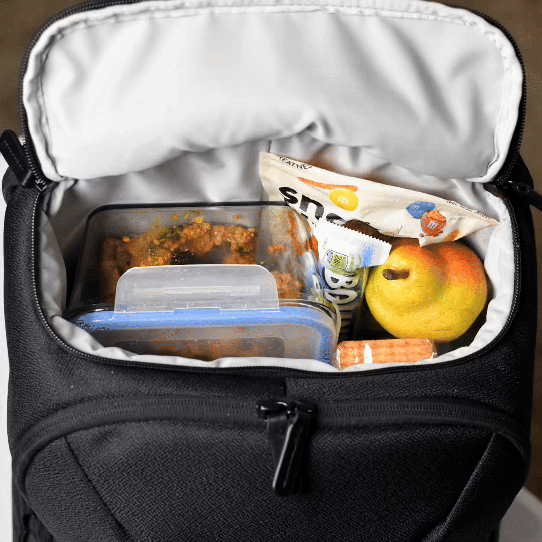 Open laptop backpack showing organized interior with a book and wireless headphones neatly stored inside.